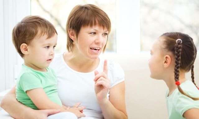 woman-holding-kid-talking-to-girl